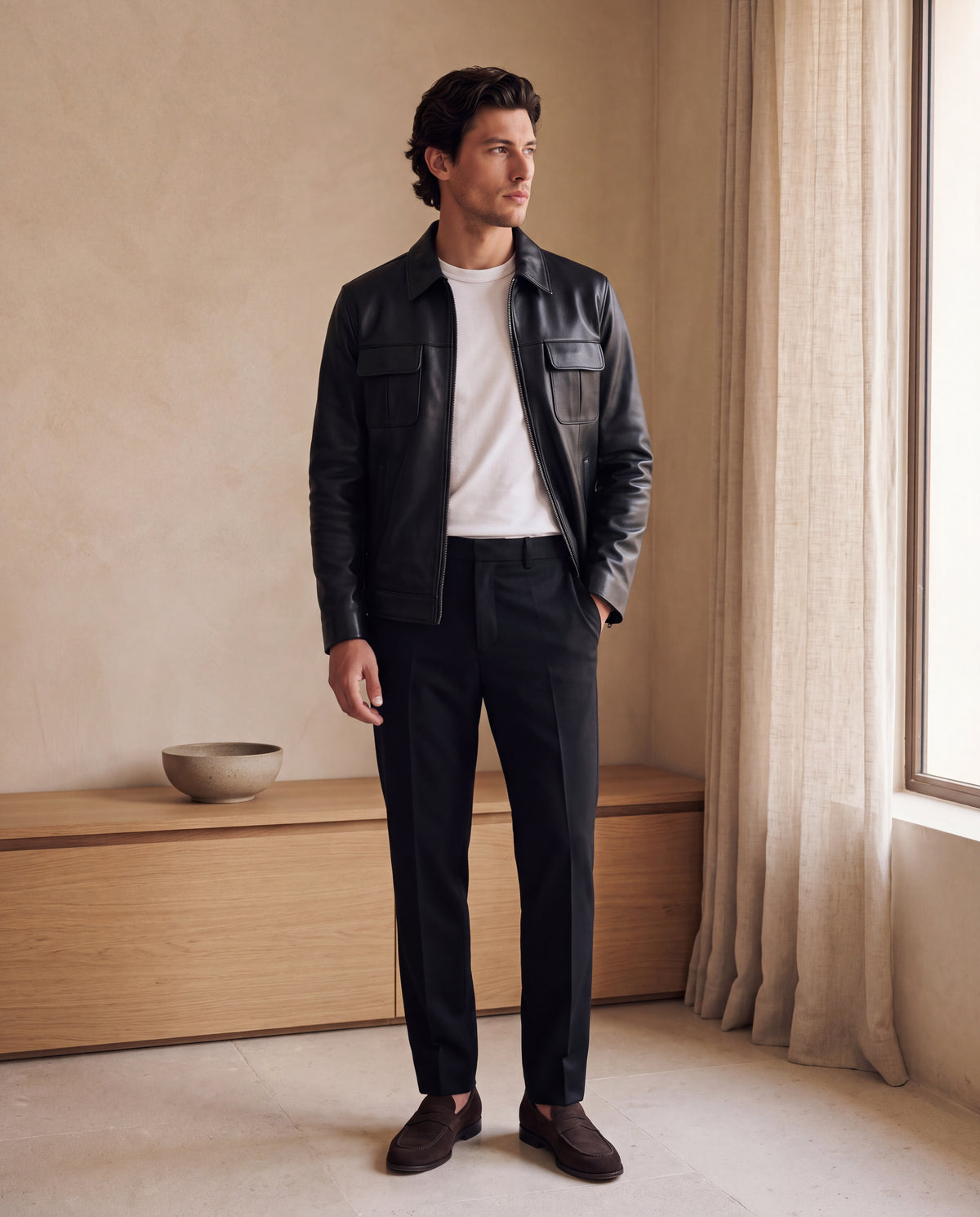 Veste-chemise Varenne en cuir d'agneau noir lisse portée dans un intérieur minimaliste